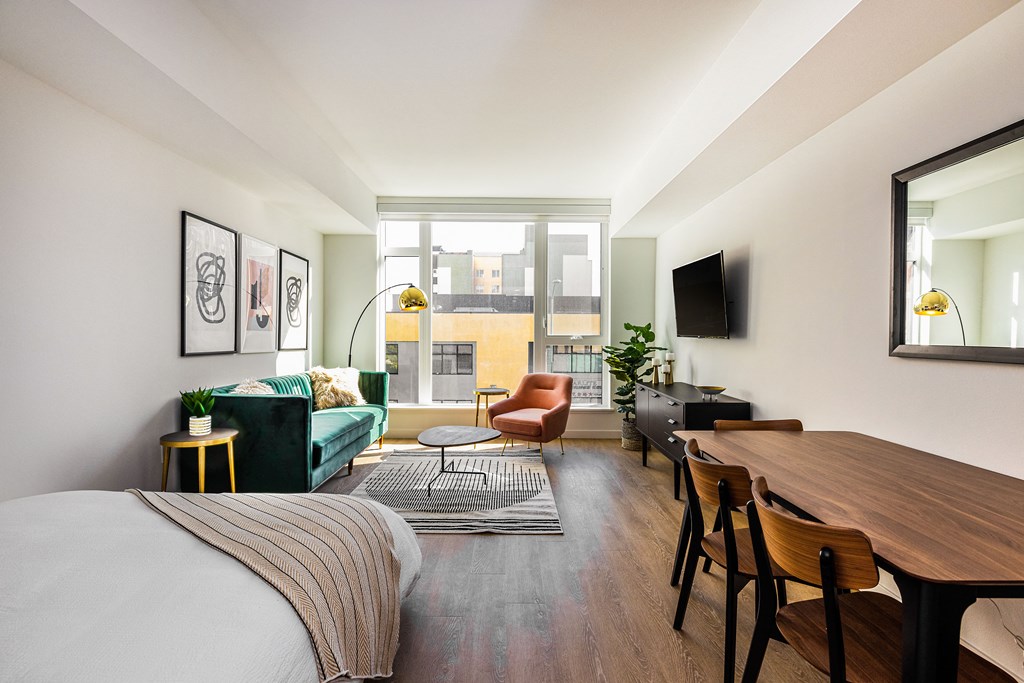 a bedroom with a bed and a living room with a couch and a table