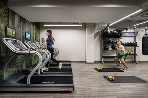 Fitness center with cardio equipment and free weights at 923 Folsom Apartments, San Francisco, California