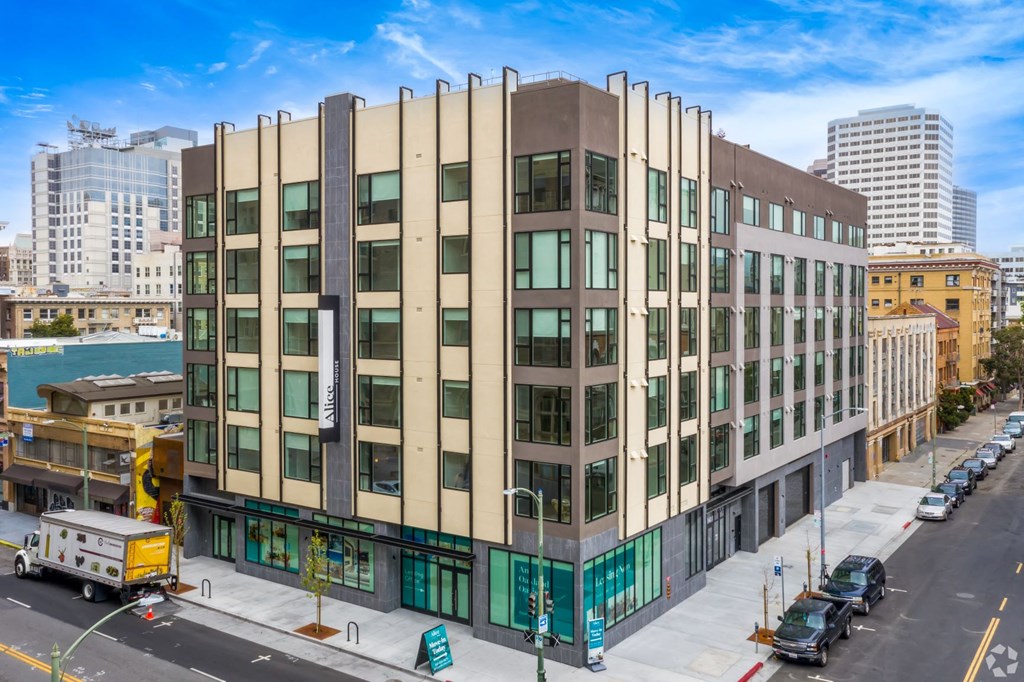 1 Bedroom Luxury Apartments in Downtown Oakland CA - Alice House - Property Exterior During the Daytime, with Grey and Tan Walls, Windows, and Street View