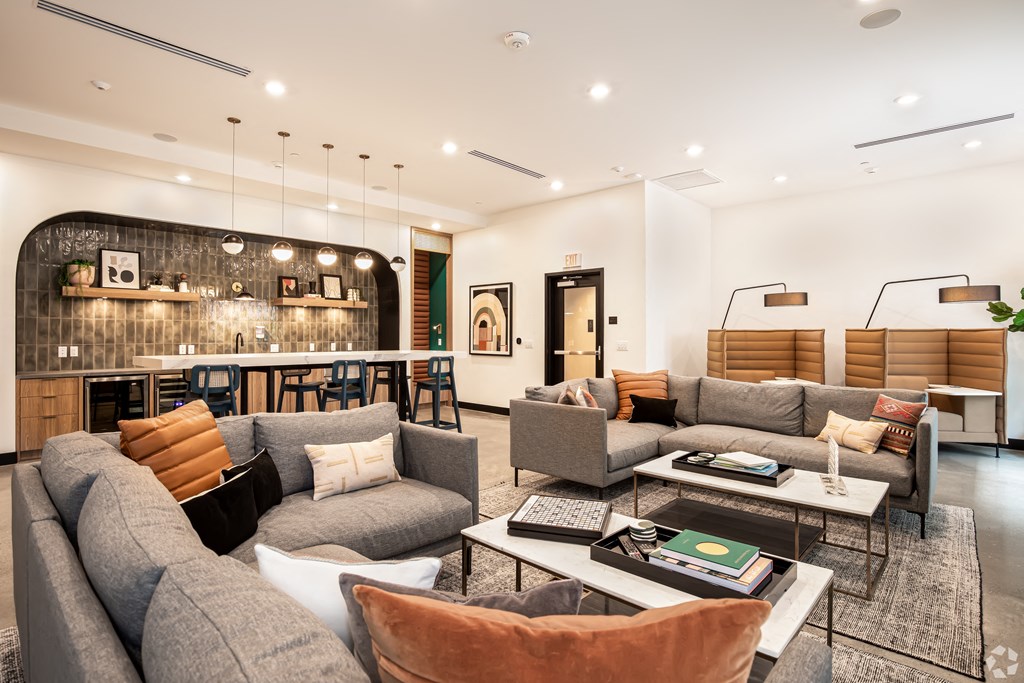a living room with couches and chairs and a bar