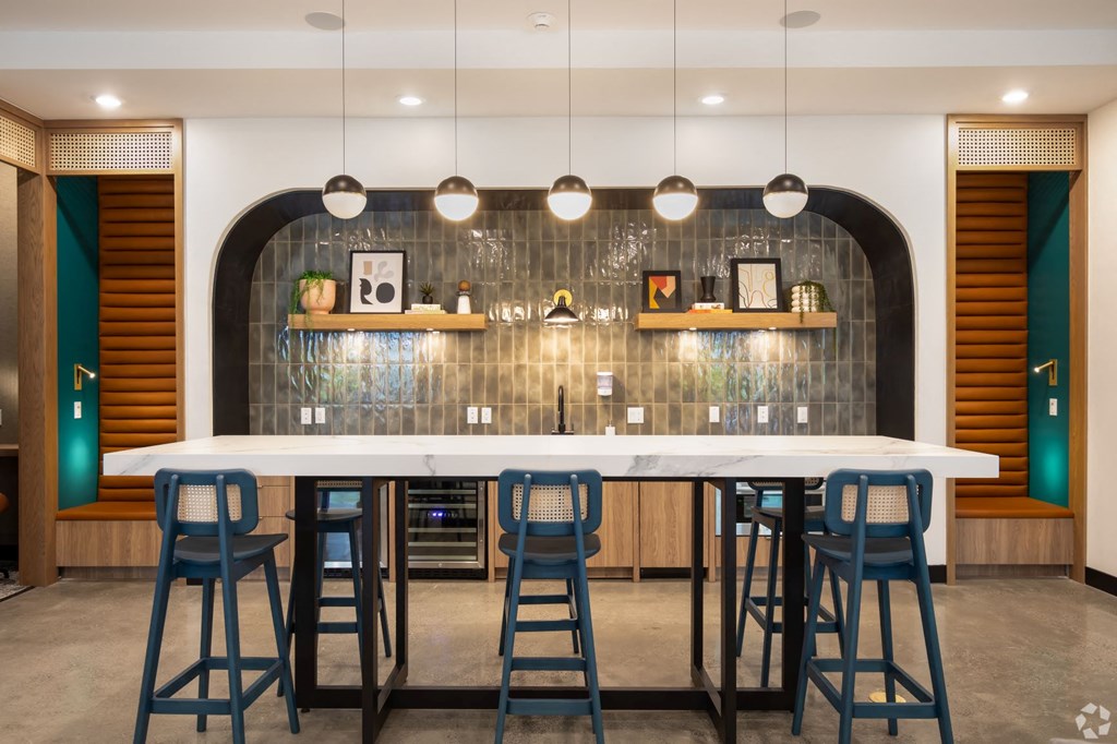 a large bar with blue stools in front of a white counter top