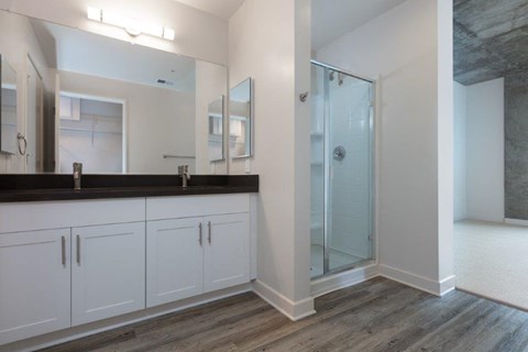 Oakland CA Apartments-Aqua Via Apartments Bathroom With Glass Door Shower And Double Sink Vanity And Vinyl Plank Flooring at Aqua Via Apartments, Oakland, California