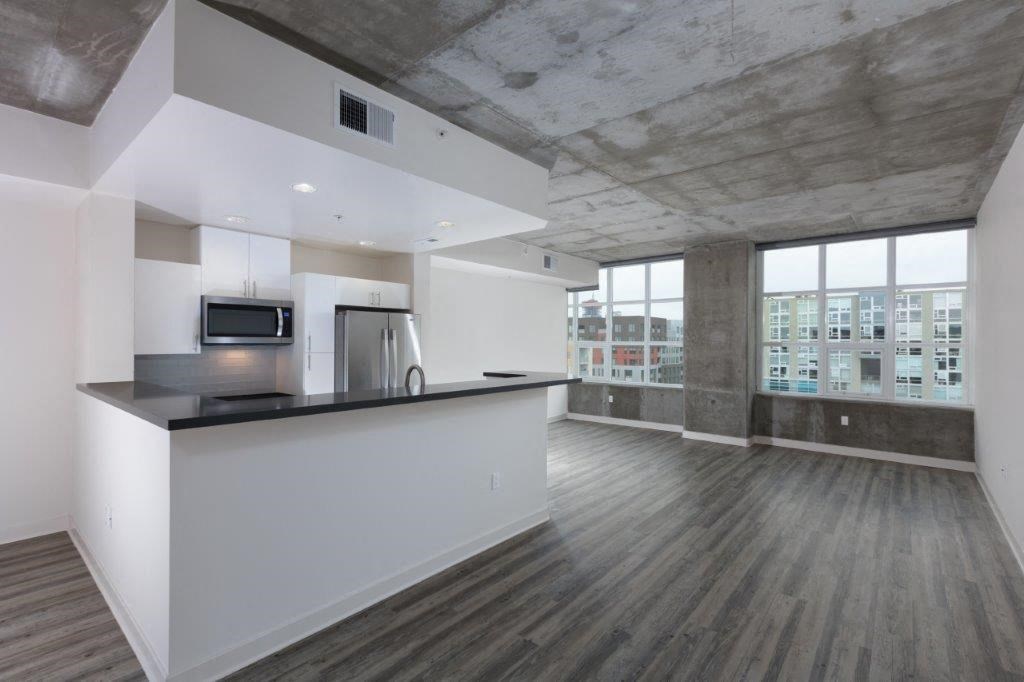 Kitchen with stainless steel appliances and living area with large windows