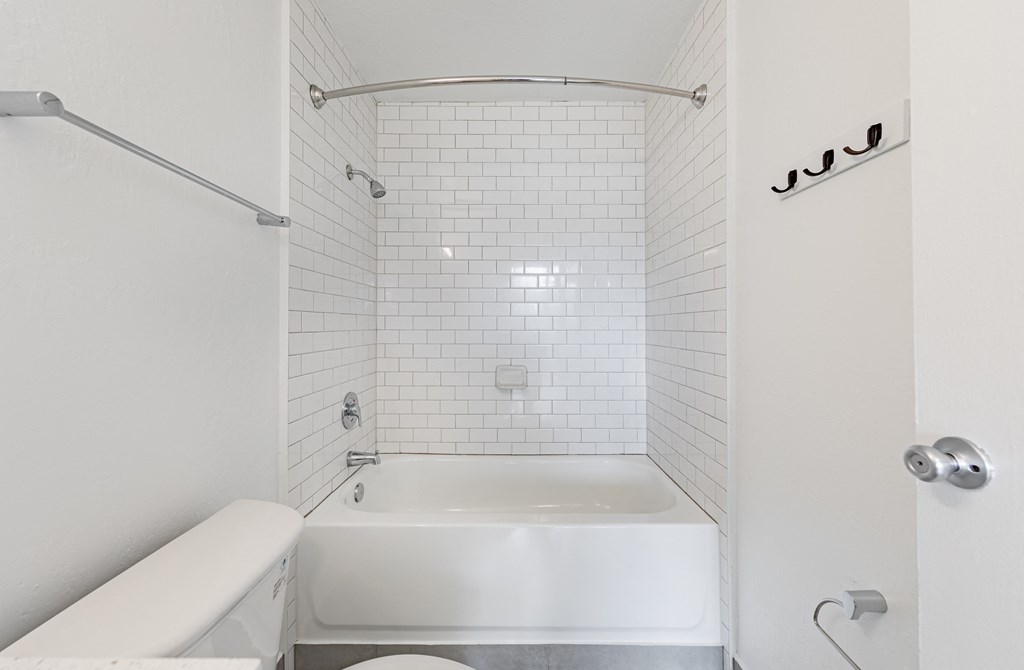 a white bathroom with a tub and a toilet at Avenue Two Apartments, Redwood City  ,California, 94063