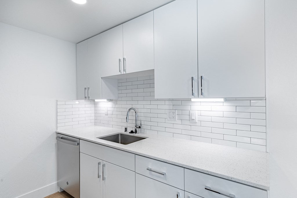 a white kitchen with white cabinets and a sink at Avenue Two Apartments, Redwood City  , California
