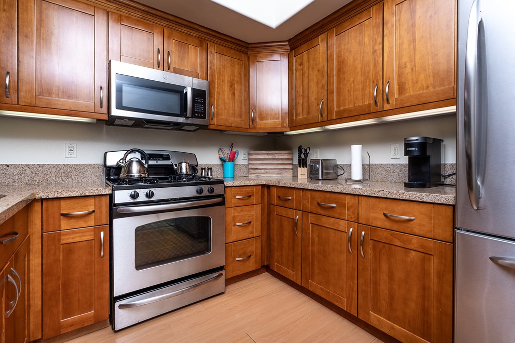 a kitchen with wood cabinets and stainless steel appliances