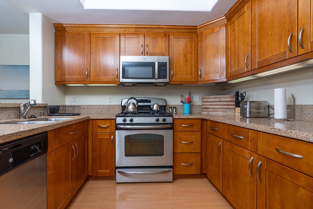 a kitchen with wood cabinets and stainless steel appliances