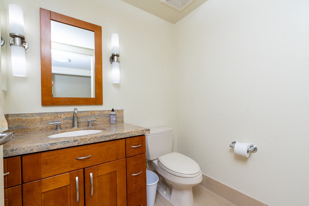 a bathroom with a toilet sink and mirror