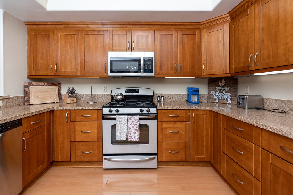 a kitchen with wooden cabinets and stainless steel appliances
