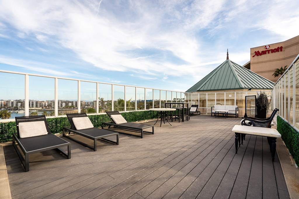 a rooftop deck with lounge chairs