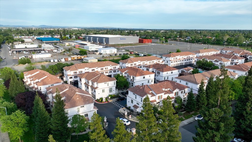 A large white building complex surrounded by trees.