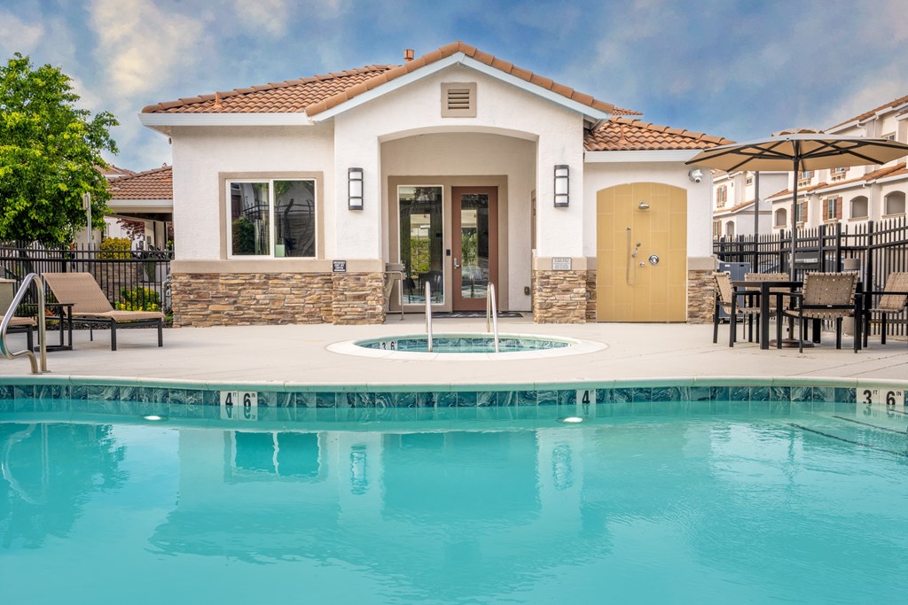 A pool in front of a house with a yellow door.