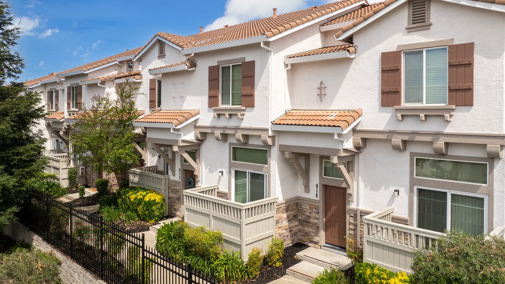 A row of houses with a black fence in front.