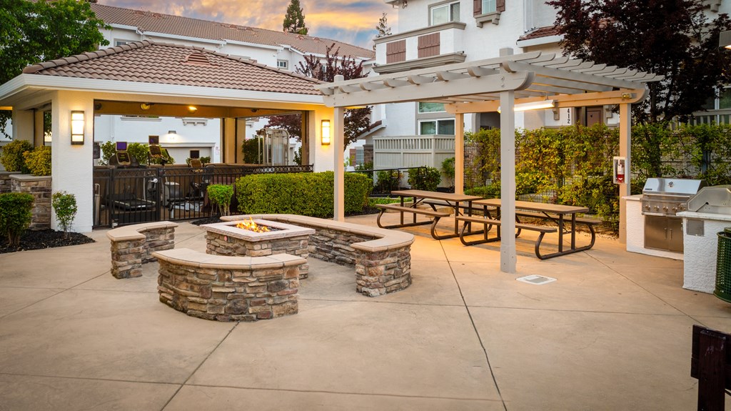 A patio with a fire pit and seating area.