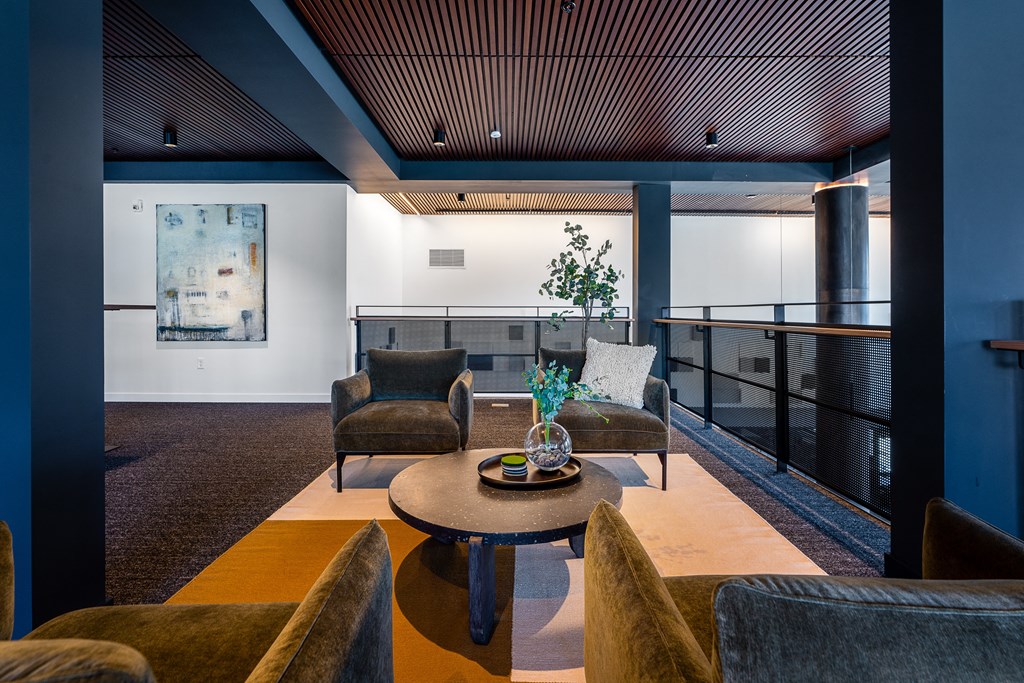 a living room with blue and white walls and a brown table with a vase of flowers