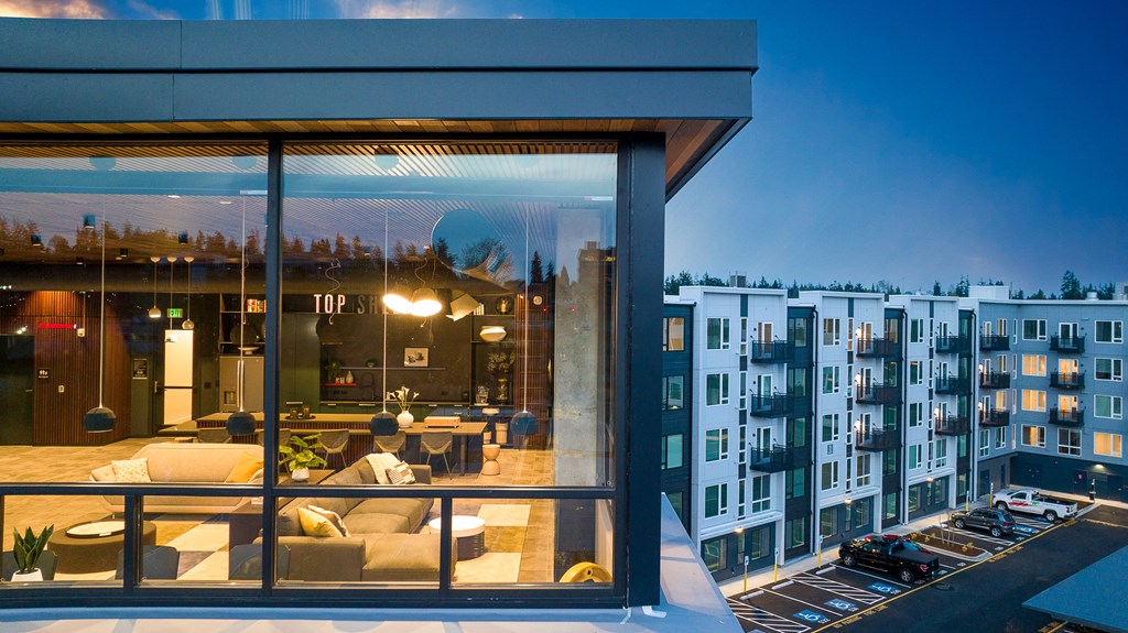 a man sitting on a couch in front of a large window