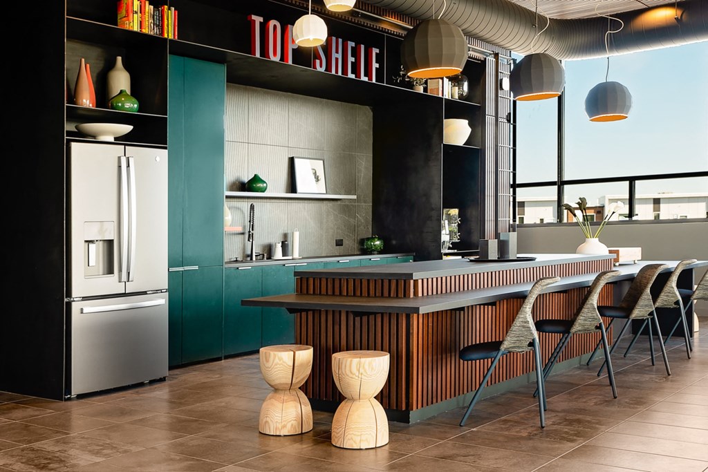 a kitchen with green cabinets and a white countertop with wooden stools