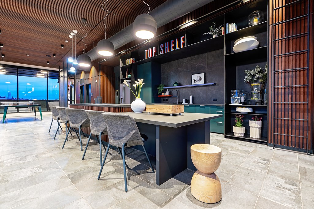 a long table with chairs in a room with a pool in the background