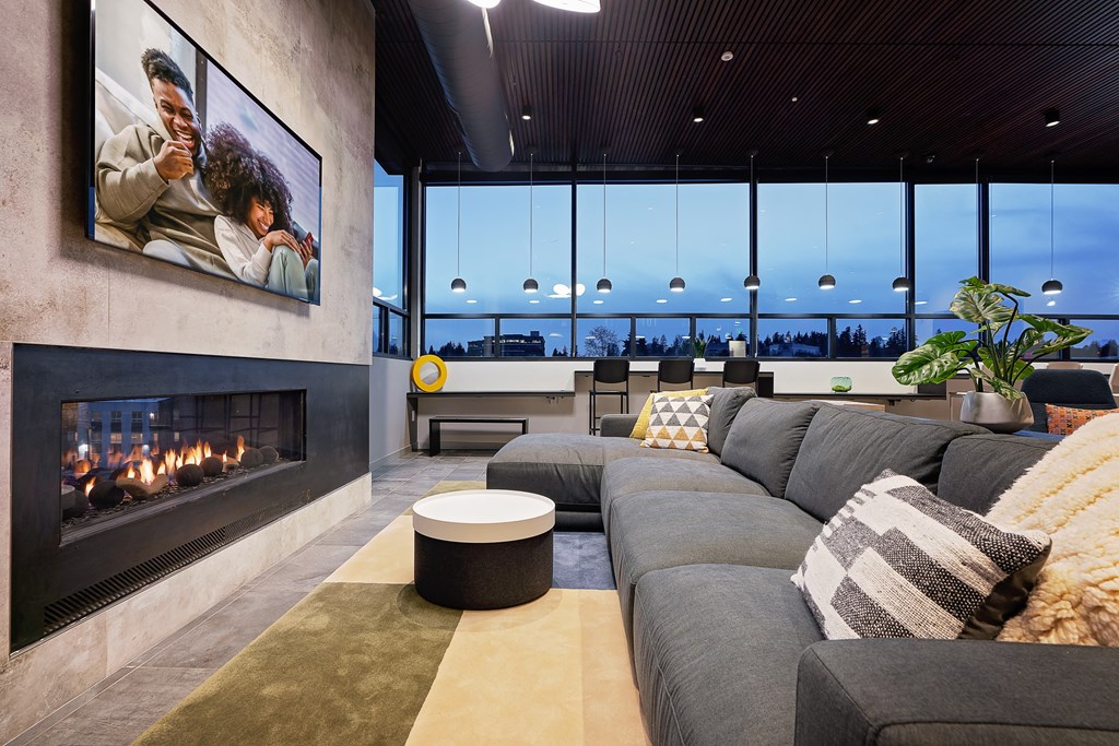 a living room with a large gray couch and a fireplace