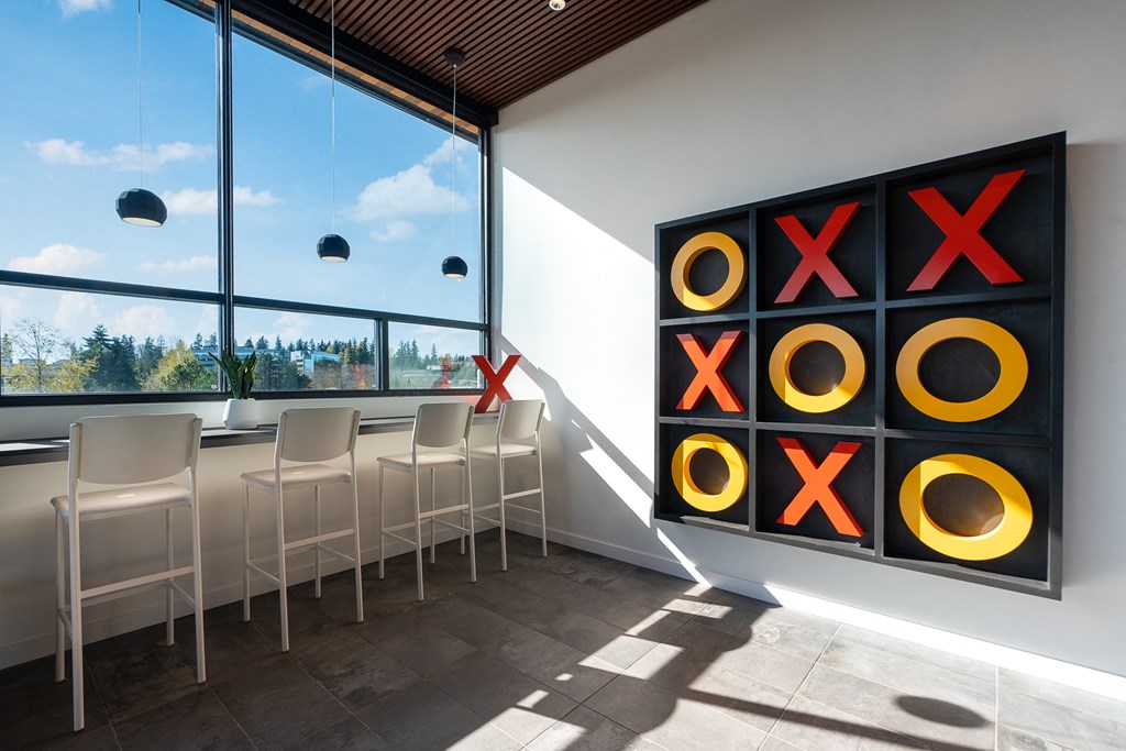 a large painting of circles on a wall next to a window with a view of a city