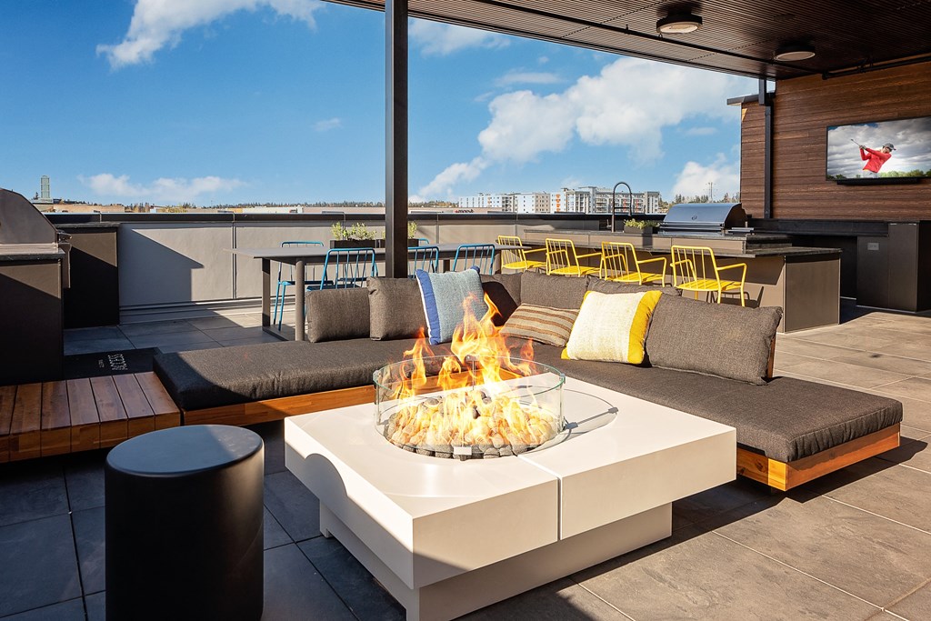 a fire pit on the roof of a building with a television in the background