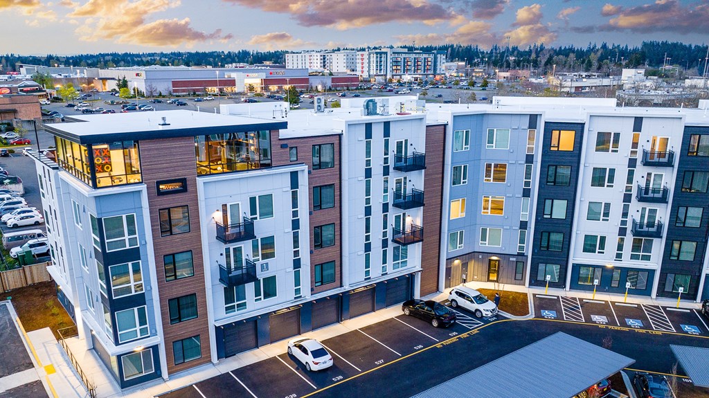 an aerial view of an apartment complex with a sunset in the background
