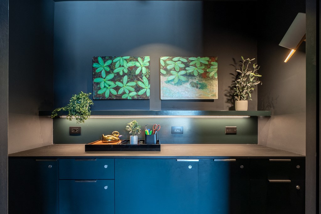 a kitchen with blue cabinets and two paintings on the wall