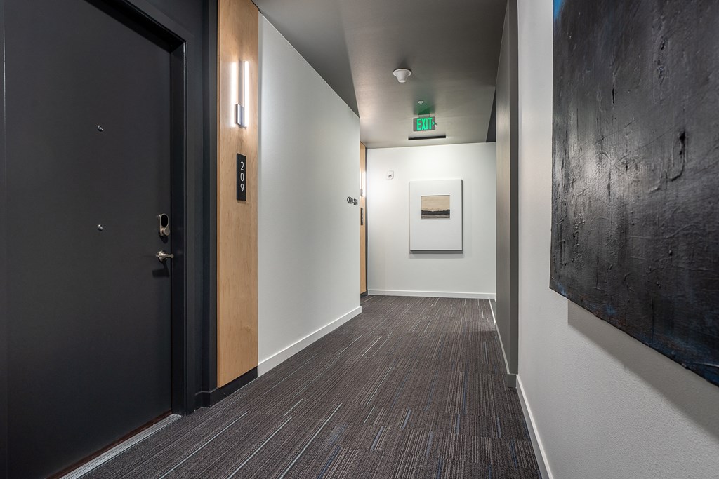 a view down a hallway with a black door and white walls