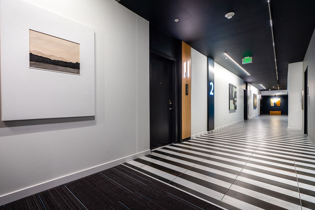 a hallway with a black ceiling and white walls and a black and white checkered floor