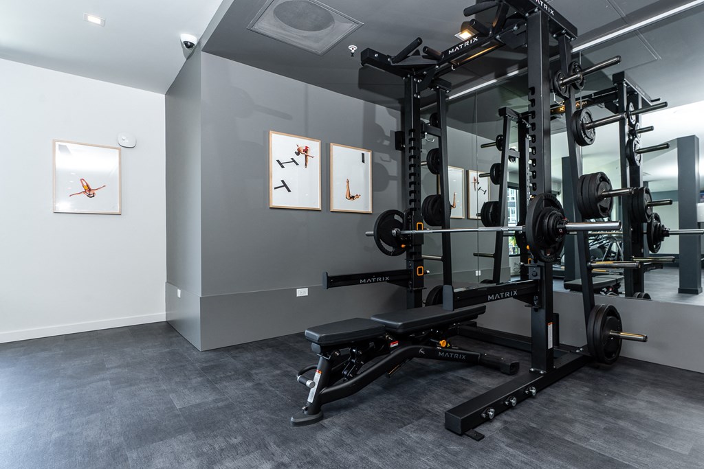 a view of the fitness room with the exercise equipment and paintings on the wall