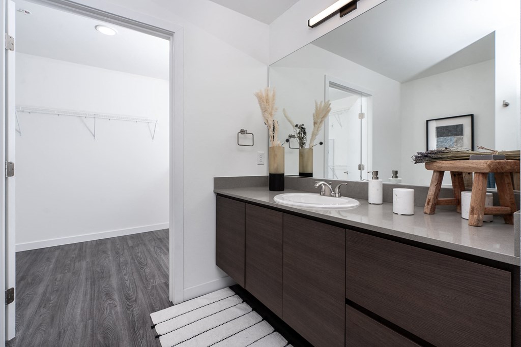 a bathroom with white walls and a wooden floor