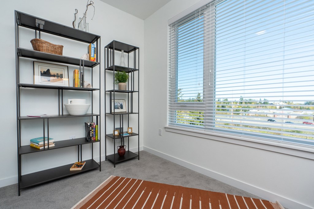 a room with a large window and a bookshelf