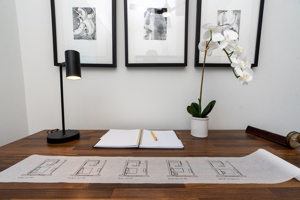 a desk with a notebook and a lamp on it
