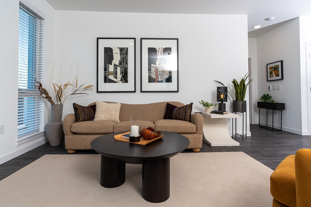 a living room with a brown couch and a black coffee table