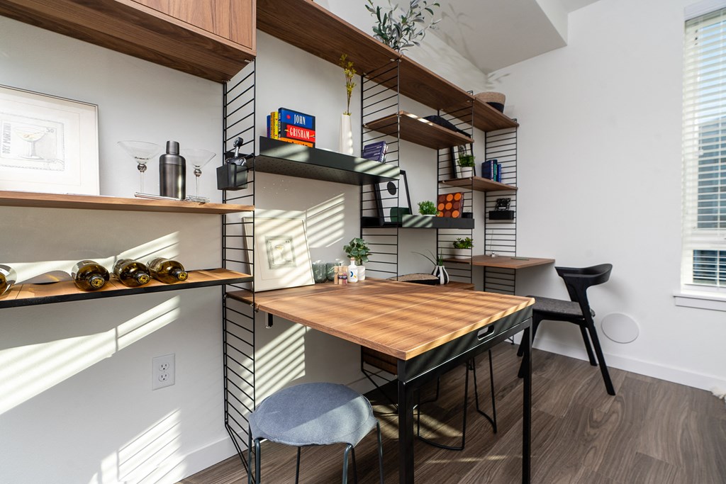 a small dining area with a wooden table and two black chairs