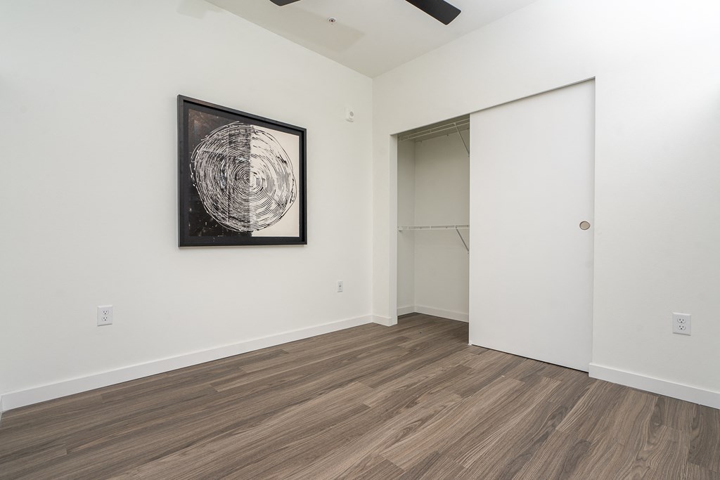 a bedroom with white walls and a wooden floor