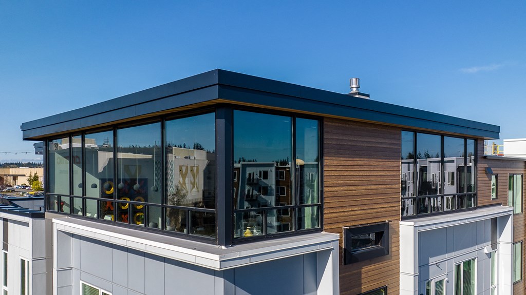 a home with large glass windows and a black roof on top of a building