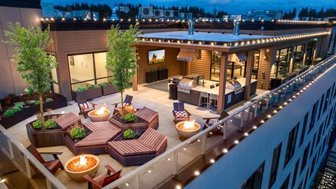 A rooftop patio with a fire pit and seating area.