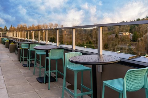 Outdoor seating with green chairs and tables.