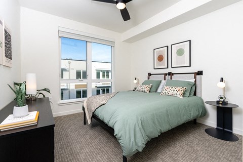 Bedroom with dresser, ceiling fan and dinwos
