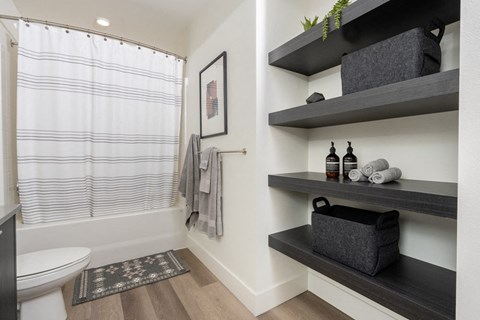 A modern bathroom with dark wood and white fixtures