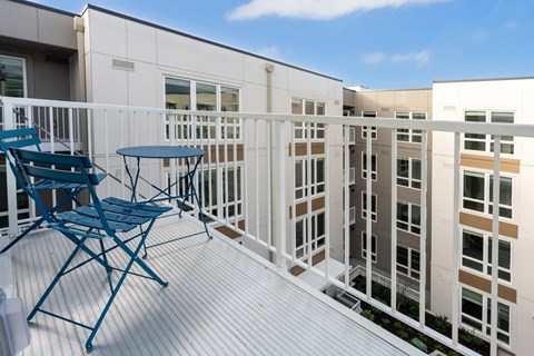 A balcony with a blue chair and table.