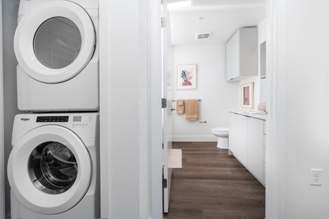 A white washing machine is in a laundry room.