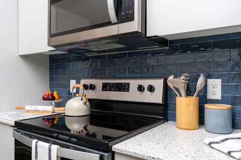 A modern kitchen with a black stove top and a microwave