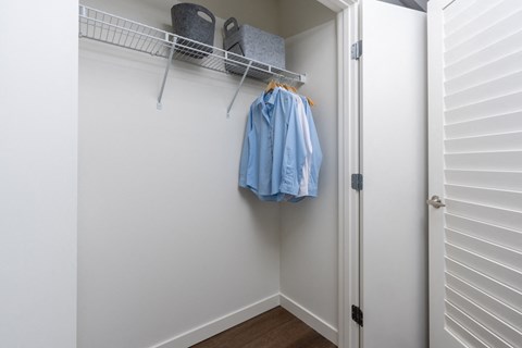 A blue shirt hanging on a white door.