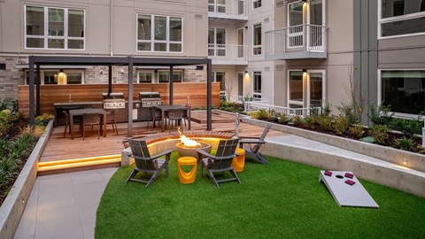 A backyard with a fire pit and chairs.