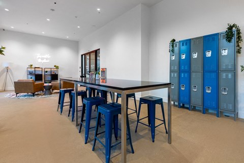 A room with a long table and blue stools.