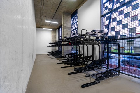 A room with a row of black bicycle racks.