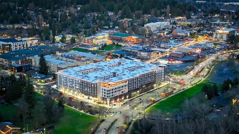 A cityscape at night with buildings, roads, and lights.