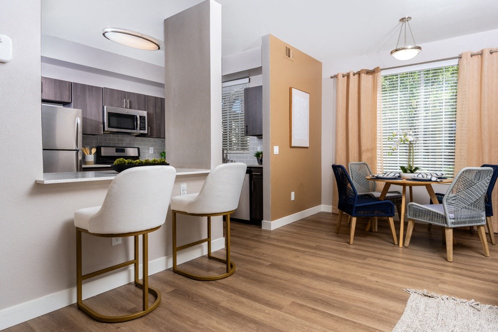 a living room and kitchen with a dining room table and chairs